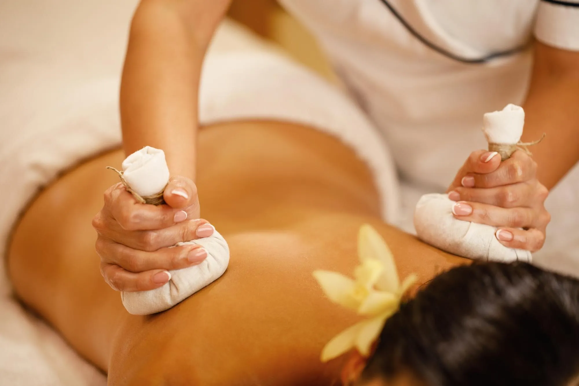 Back massage with warm herbal bolus bags